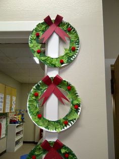 paper plate christmas wreaths hanging on the wall