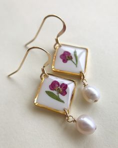 Wildflower Dangle Earrings with Pearls. Each piece contains a single Alyssum flower stem and leaf. They are carefully arranged and conserved in layers of white and clear resin. Freshwater pearls add a classy/vintage look to them. Choose from either a french wire hook, or a kidney wire hook. Available in two colors. Approx. length is 1 ¼ inches. Keep in mind that no two flowers are exactly the same so your piece will be truly one-of-a-kind! I try to make each piece so that it resembles the photo. Delicate Birth Flower Earrings For Anniversary, Flower-shaped Earrings For Wedding Gift, Floral Birth Flower Earrings For Anniversary, Birth Flower Earrings For Anniversary, Anniversary Birth Flower Earrings, Dainty Flower Earrings For Anniversary, Elegant Wedding Earrings With Birth Flower, Minimalist Flower-shaped Formal Jewelry, Dainty Flower Charm Earrings For Anniversary