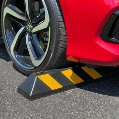 a red sports car is parked on the side of the road with yellow caution tape