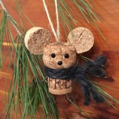 a cork mouse ornament hanging from a pine tree