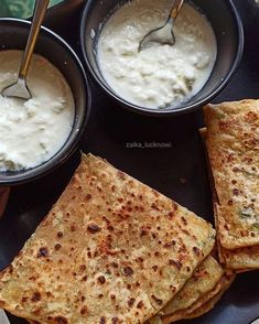 there are some pita bread and dips on the plate