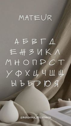 the letters are written in different languages on the wall above a bed with sheets and pillows