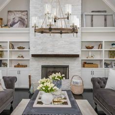 a living room with two couches and a coffee table in front of a fireplace