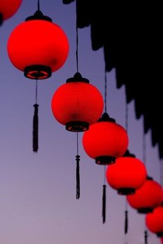 red lanterns are hanging from the ceiling at dusk