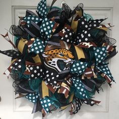 a wreath made out of mesh and fabric with a jacksonville football design on it, hanging on the front door