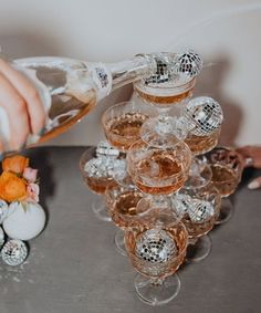 a person pouring champagne into glasses on top of a table