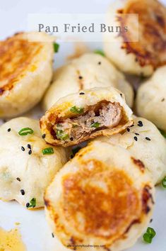 some fried buns on a white plate with green onions