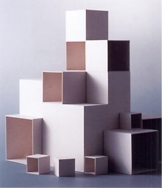 several cubes stacked on top of each other in front of a white wall and floor