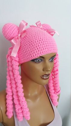 a pink crocheted hat with large bows