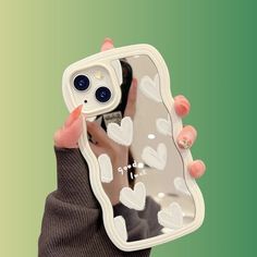 a person holding up a phone case with hearts on it