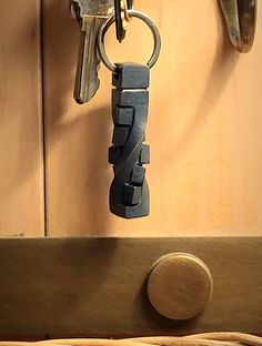 a bunch of keys that are hanging from a hook on a wooden door with a keychain attached to it