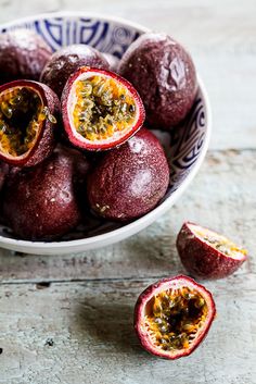 a bowl filled with fruit sitting on top of a wooden table