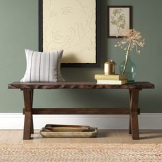 a wooden bench sitting in front of a painting on the wall next to a rug