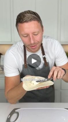 a man in an apron holding a piece of bread