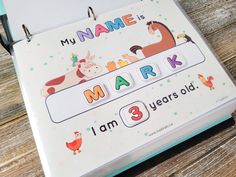 a close up of a book on a wooden table with animals and letters written in it