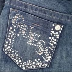 a pair of jeans with silver sequins on the side and an embroidered pocket