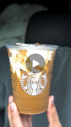 someone holding up a starbucks cup in their hand with the video on it's screen