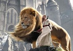 a woman in white dress walking next to a lion on top of a rock formation