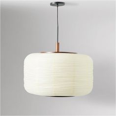 a white lamp hanging from a ceiling with a light fixture in the middle of it