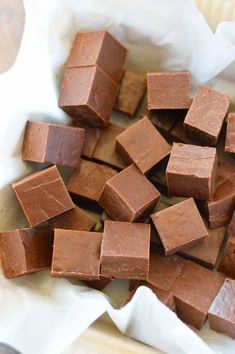 pieces of chocolate sitting on top of a white paper wrapper next to a fork