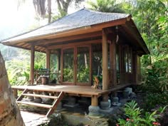 a small wooden building surrounded by trees and plants