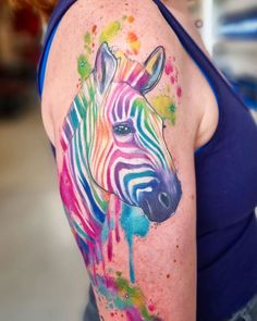 a woman's arm with a colorful zebra tattoo on the left side of her body