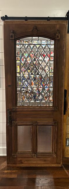 an old wooden door with stained glass window in the center and wood flooring around it