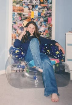 a woman sitting in a bubble chair talking on the phone