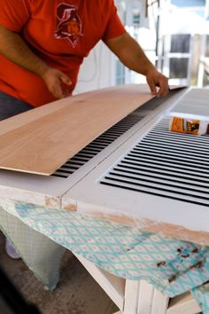 a man is working on an unfinished piece of wood that has been cut into pieces