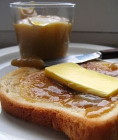 two pieces of bread on a plate with butter and jelly