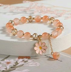 Introducing Our Stunning Peach Pink Color Flower Charm Glass Beaded Bracelet A Beautiful Accessory That Will Add A Touch Of Feminine Elegance To Any Outfit! This Bracelet Is Crafted With Care And Features Delicate Glass Beads In A Gorgeous Peach Pink Color That Exudes Softness And Sophistication. With Its Adjustable Length, This Bracelet Can Comfortably Fit Most Wrist Sizes. The Stretchy Band Ensures A Secure And Flexible Fit, Allowing You To Easily Slide It On And Off Without Any Hassle. The Fl Elegant Adjustable Crystal Bracelet For Spring, Elegant Flower Crystal Bracelet For Spring, Elegant Flower Shaped Crystal Bracelet For Spring, Spring Crystal Bracelet With Round Beads, Elegant Flower Beaded Bracelets For Spring, Elegant Spring Flower Beaded Bracelets, Elegant Spring Bracelet With Colorful Beads, Elegant Beaded Flower Bracelets For Spring, Spring Coral Jewelry