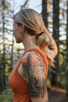 a woman with a forest tattoo on her arm and shoulder, looking at the woods