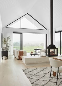 a living room filled with furniture and a fire place next to a large glass window