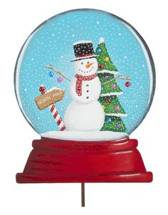 a snow globe with a christmas tree and a snowman on it's side