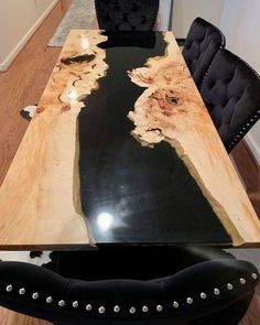 a dining room table made out of wood with black leather chairs and a cowhide rug