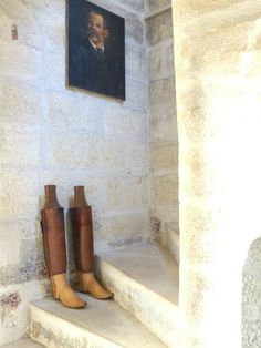 two brown boots are sitting on the steps in front of a painting hanging above them