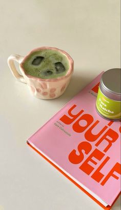 a cup of green tea next to a book with the title you're sell written on it