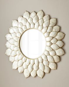 a white mirror sitting on top of a wall next to a flower shaped frame in the shape of a sunflower