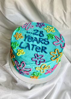 a birthday cake with the words 28 years later written on it and decorated with flowers