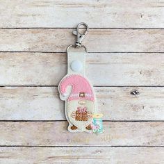 a keychain with a pink and white teddy bear on it's side