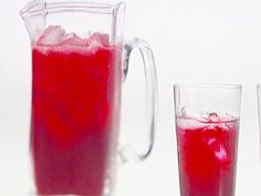 three pitchers filled with red liquid next to each other