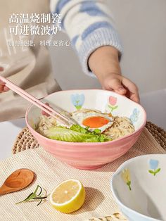 a person holding chopsticks over a bowl of food