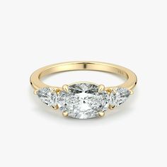 three stone diamond ring in yellow gold with diamonds on the band and side stones at each end