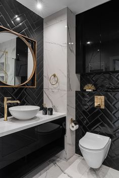 a white toilet sitting next to a bathroom sink under a round mirror on a wall