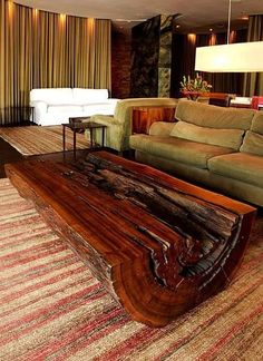 a living room filled with furniture and a large wooden table on top of a rug