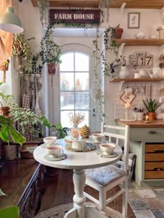 a table with two chairs and some potted plants on top of it in front of a window