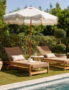 two lounge chairs and an umbrella next to a swimming pool