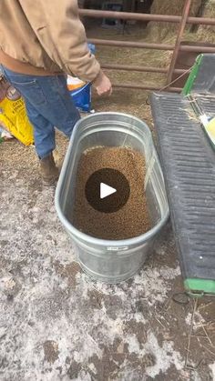 a man standing next to a bucket filled with dirt