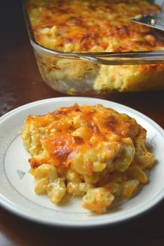 a white plate topped with macaroni and cheese next to a casserole dish