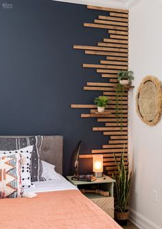 a bed room with a neatly made bed next to a night stand and some plants